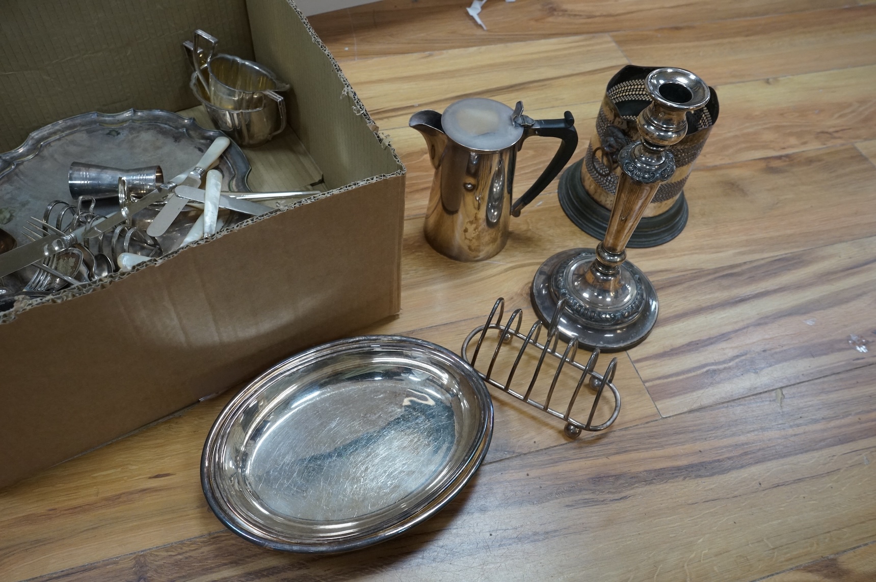 A group of assorted plated ware, including a pair of candlesticks, a salver, toast rack and cutlery including set of mother of pearl handled dessert eaters, together with a George V silver mounted trinket box and two sil